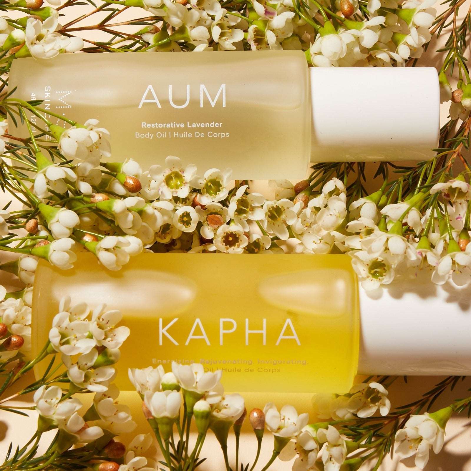 M.S Skincare AUM Lavender Restorative Body Oil -luxury skincare in a frosted white bottle on a bed of white flowers.