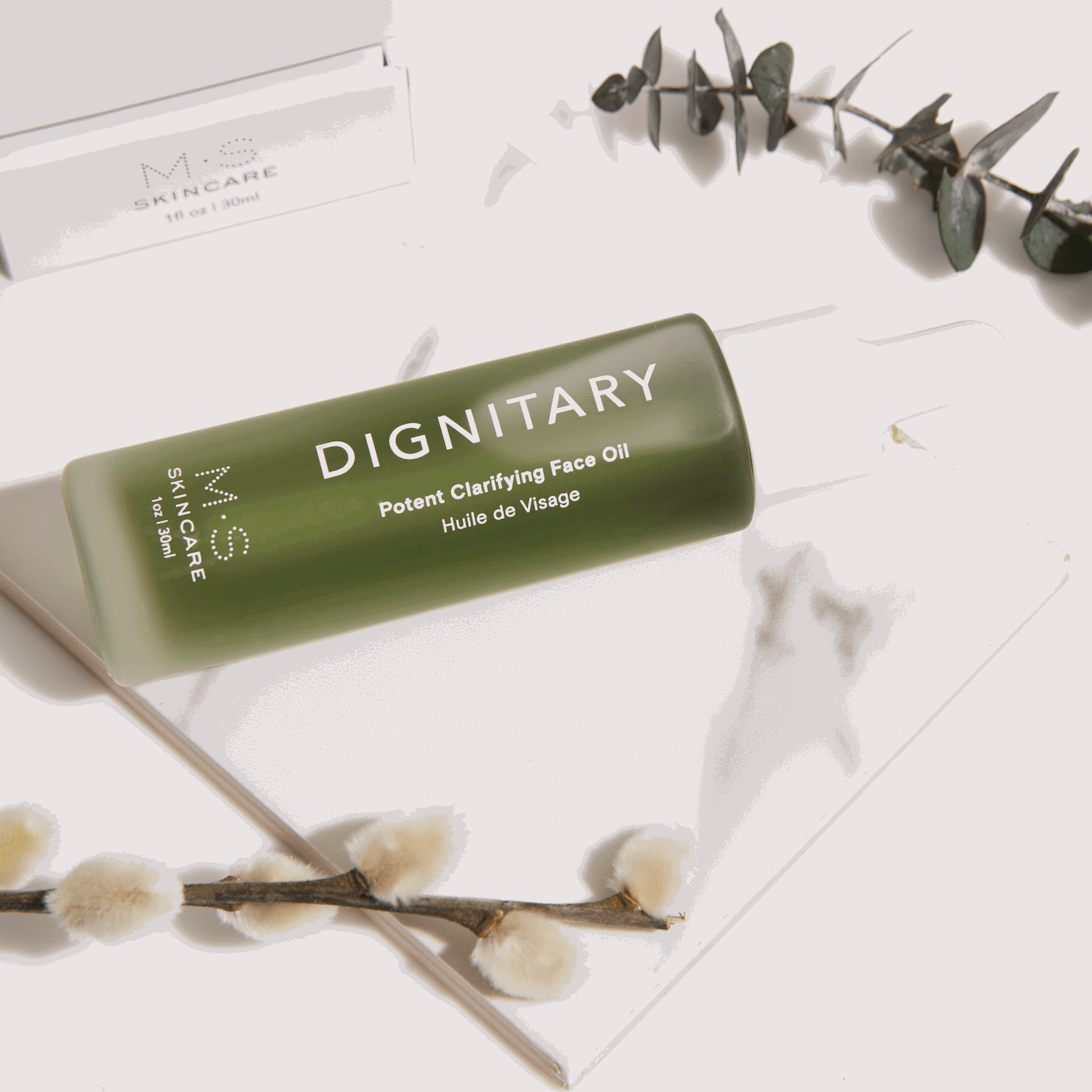 M.S Skincare DIGNITARY Clarifying Face Oil- green ayurvedic face oil in a frosted bottle with dropper -lifestyle image.